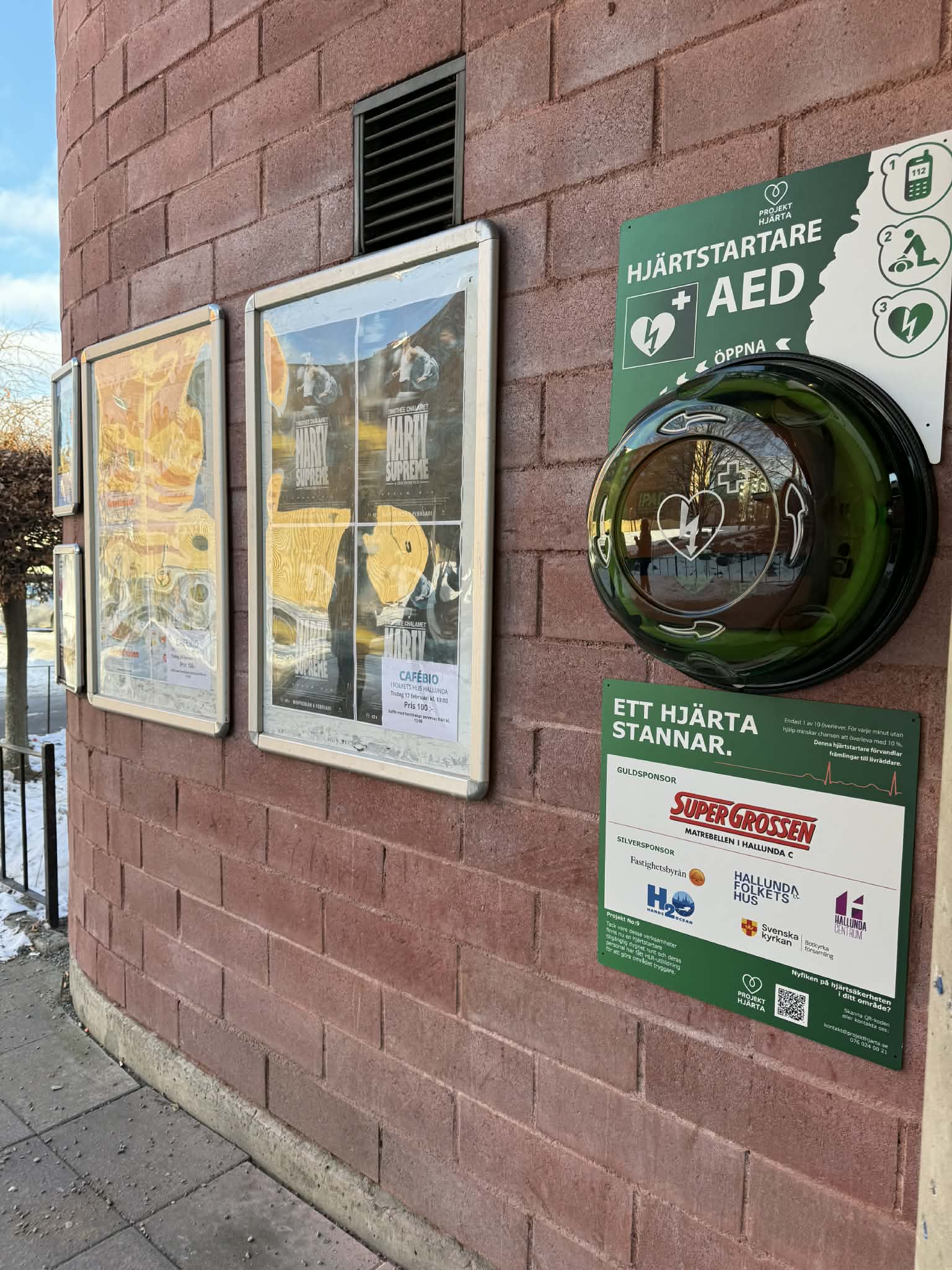 Hjärtstartare i skåp med sponsortavla, Folkets Hus Hallunda i Norsborg