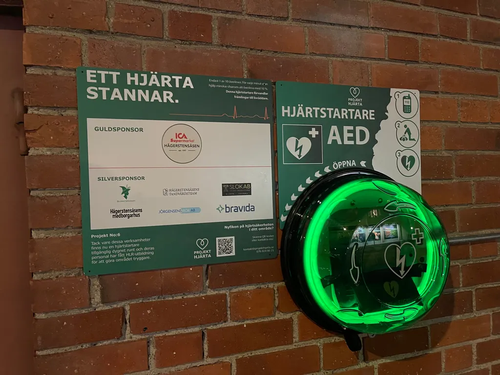 Hjärtstartare i skåp med sponsortavla, Hägerstensåsens Medborgarhus i Hägersten